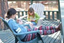 mother and daughter doing crafts on a back porch 