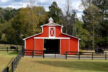 A red barn and fenced in farm land 