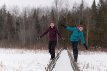 teen girls balancing on railings in winter snow 
