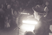 a man singing into a microphone at a worship service 