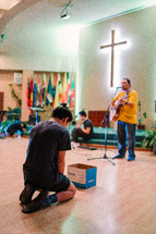 teens kneeling on the floor during a worship service 