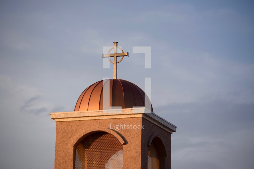 cross at the top of a mission style church steeple 
