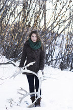 a woman holding antlers in the snow 