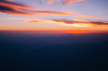 A colorful sunset over hazy mountains.