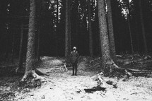 man backpacking in a snowy forest 