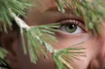 a woman looking through tree branches 