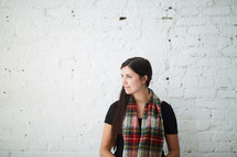 a woman standing in a plaid scarf 