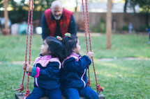 children swinging on a swing 