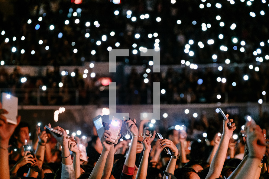cellphones taking pictures at a concert 