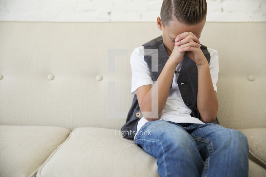 boy child with head bowed in prayer