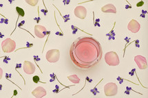 Rose Wine In Glass With Spring Flowers and Petals Background