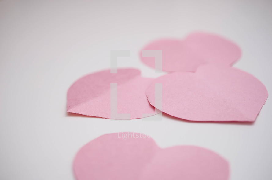 pink paper hearts on a white background 