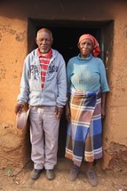 mand and a woman standing in the doorway of their home 