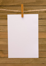 blank white paper hanging by clothespins 