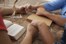 holding hands in prayer at a Bible study 