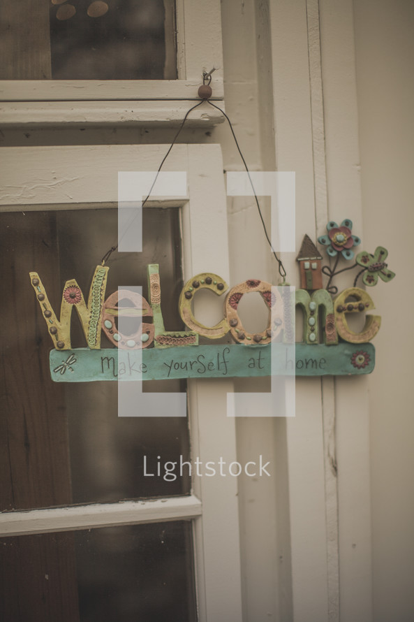 A welcome sign hanging from a window