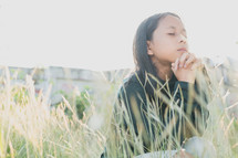 girl praying in a field 
