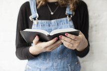 torso of a young women reading a Bible 