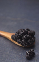 wooden spoon full of blackberries 