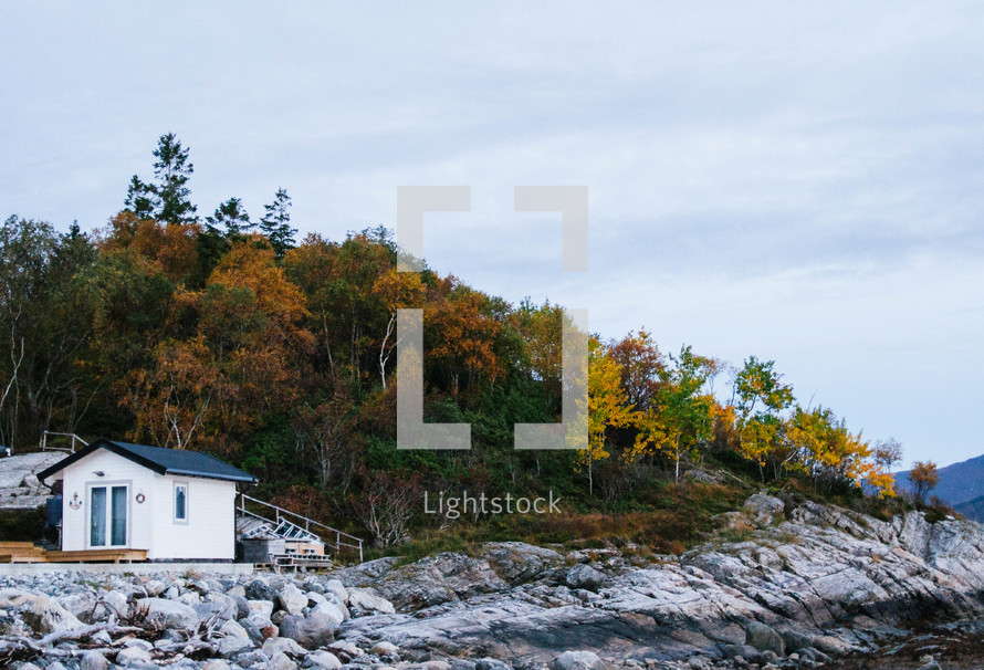 a cabin on a rocky shore in fall 