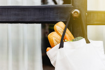 grocery bag hanging on a doorknob 