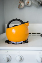 yellow kettle on a gas stove 