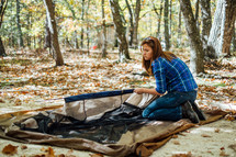 a woman setting up a tent 