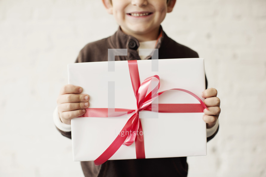 a young boy holding a wrapped present 