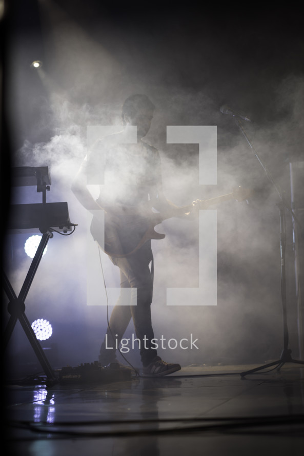 guitarist on stage under smoke