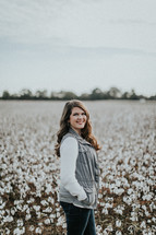 a woman standing in a field of cotton 