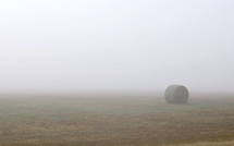 hay bale in a foggy field 