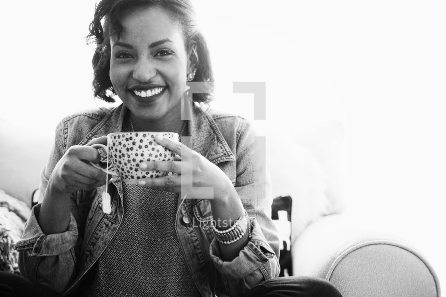 An African American woman holding a cup of hot tea 