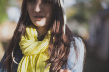 A young woman wearing a yellow scarf