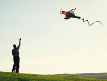 man flying an airplane kite 