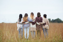 a group of young woman standing in a field 
