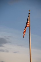 American flag on a flagpole at sunset 