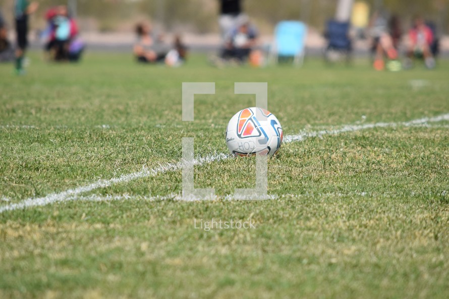 a soccer ball in bounds on the line on a soccer field 