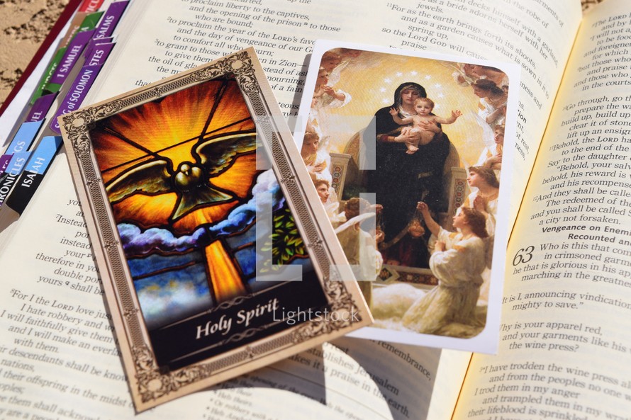 Catholic prayer cards on the pages of a Bible 