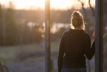 a teen girl standing outdoors at sunset 