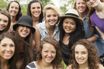 A group of smiling teenage girls together in a group. 