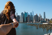 a couple holding hands with a city view 