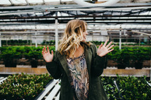 a woman standing in a garden center greenhouse 