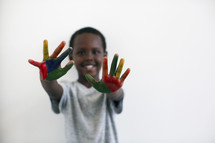 a little boy with rainbow painted hands 