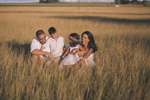 a family in tall grass at sunset 