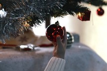 a hand on a red Christmas ornament 