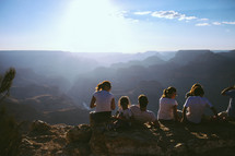 youth sitting on a mountain top under sunlight 