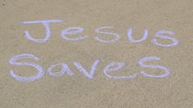 the words Jesus saves in sidewalk chalk 