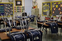 chairs on desks in an empty classroom with no students at the end of a school day