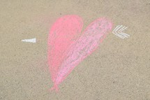 cupid's arrow through a heart in sidewalk chalk 