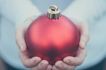 an large red ornament in a man's hands 